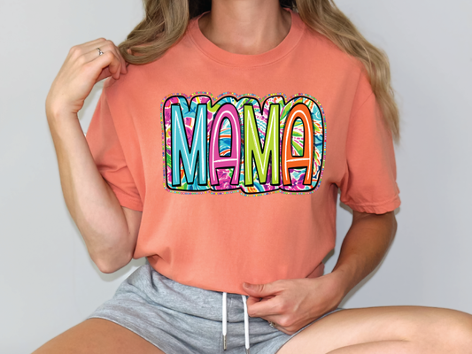 a woman wearing a pink shirt with the word mama printed on it