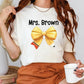 a woman holding a cup of coffee and wearing a t - shirt with a bow