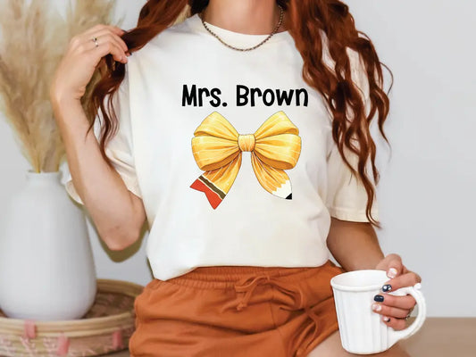 a woman holding a cup of coffee and wearing a t - shirt with a bow