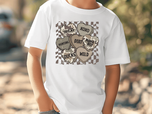 A white t-shirt with a graphic design featuring various heart-shaped symbols and text, including "TRUCKS", "XOXO", "HUNTING", "DIRT", "MAMA'S BOY", "DUCKS", and "WILD".