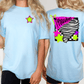 A woman wearing a light blue t-shirt with a graphic design on the back, including a star, a tornadoes graphic, and colorful stars.