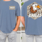 a man wearing a blue t-shirt with a graphic of an eagle and the word "EAGLES" printed on it.