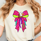 A woman wearing a white t-shirt with a colorful graphic design of an eagle wearing a pink bow.