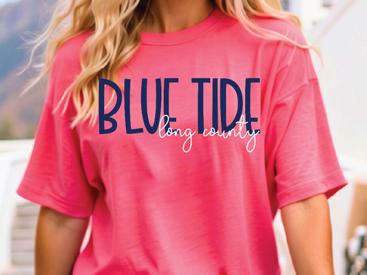 A woman wearing a pink t-shirt with the text "BLUE TIDE long county" printed on it.