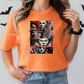 a woman wearing an orange shirt with a picture of a clown on it