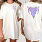 two women wearing white t-shirts with colorful, abstract designs on the back.