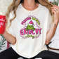 a woman wearing a grinch shirt holding a red mug