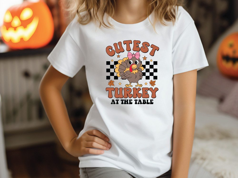 a little girl wearing a white shirt with a turkey on it