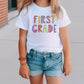 a little girl wearing a first grade t - shirt