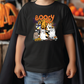 a young boy wearing a booy halloween t - shirt