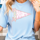 A woman wearing a light blue t-shirt with a pink and white design that says "Bears" on it.