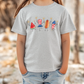 A child wearing a gray t-shirt with a graphic design of four cartoon hot dogs in different poses and colors.