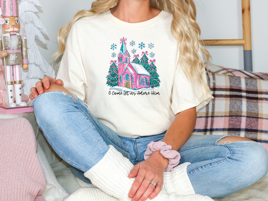 a woman sitting on a couch wearing a white t - shirt with a pink castle