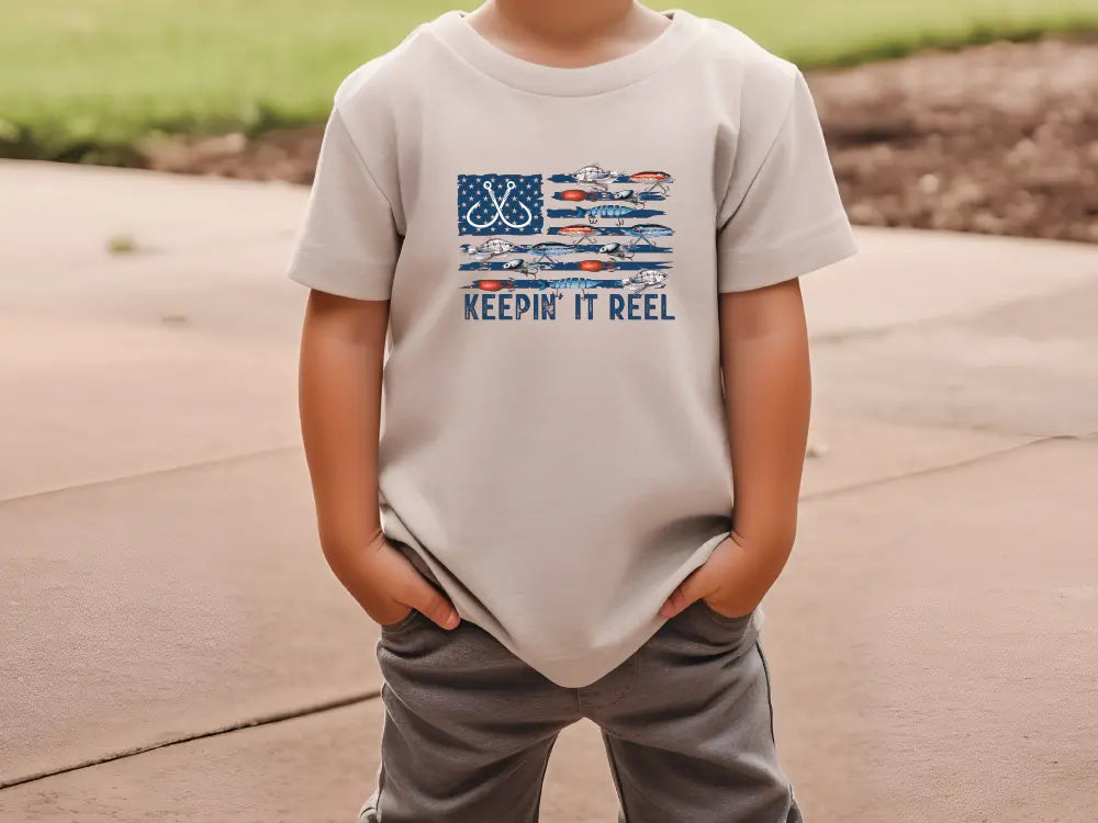 a young boy wearing a t - shirt that says keep it reel