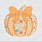 A decorative orange pumpkin with a bow, featuring a floral pattern and lace trim.