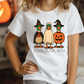 A white t-shirt with a graphic design featuring three cartoon ducks dressed in Halloween costumes, including a witch's hat, a pumpkin, and a ghost.
