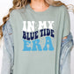 a woman wearing a shirt that says in my blue tide era