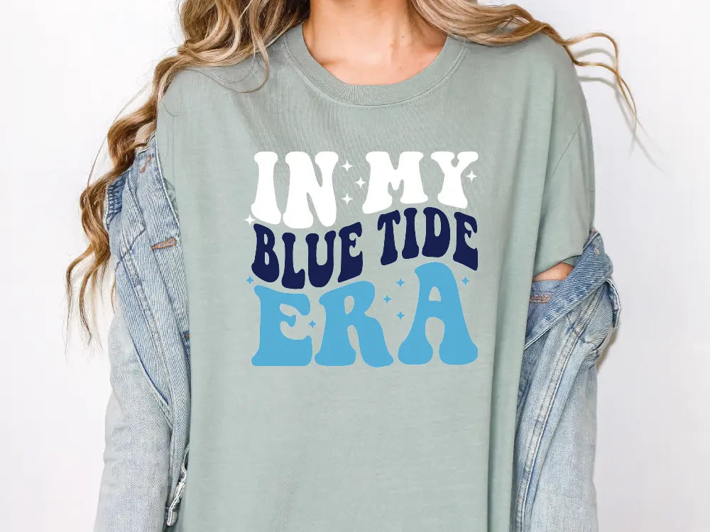 a woman wearing a shirt that says in my blue tide era