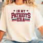 A person wearing a white t-shirt with the text "IN MY PATRIOTS ERA" printed on it.