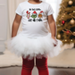 a little girl standing in front of a christmas tree