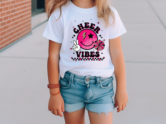 a young girl wearing a cheer vibes t - shirt