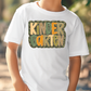 a young boy wearing a white t - shirt with the words kinder garden on