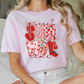 a woman sitting on a bed wearing a pink shirt