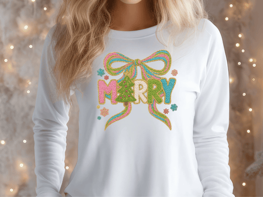 A woman wearing a white long-sleeved shirt with a colorful embroidered design on the front.