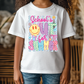 A child wearing a white t-shirt with a colorful graphic design featuring a smiley face and the text "School's out for summer".