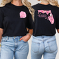 two women wearing black shirts with pink designs on them