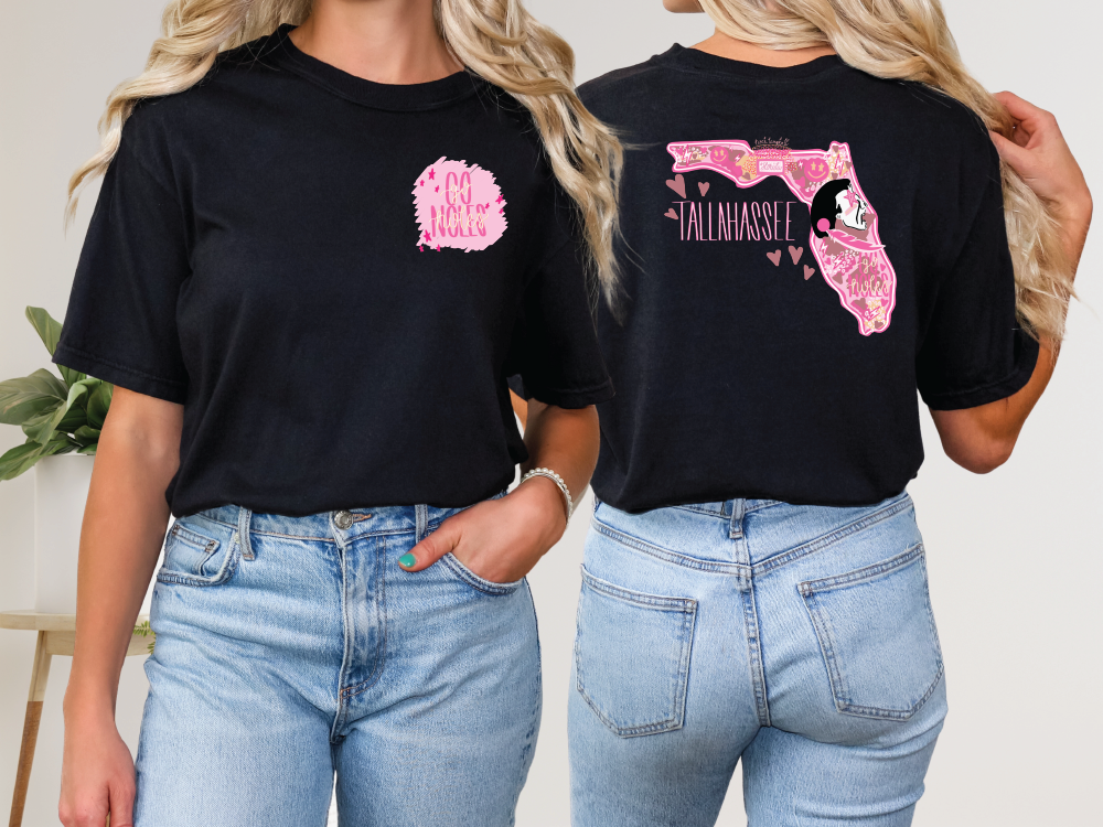 two women wearing black shirts with pink designs on them