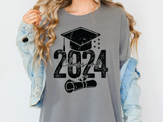 a woman wearing a gray shirt with a graduation cap and diploma