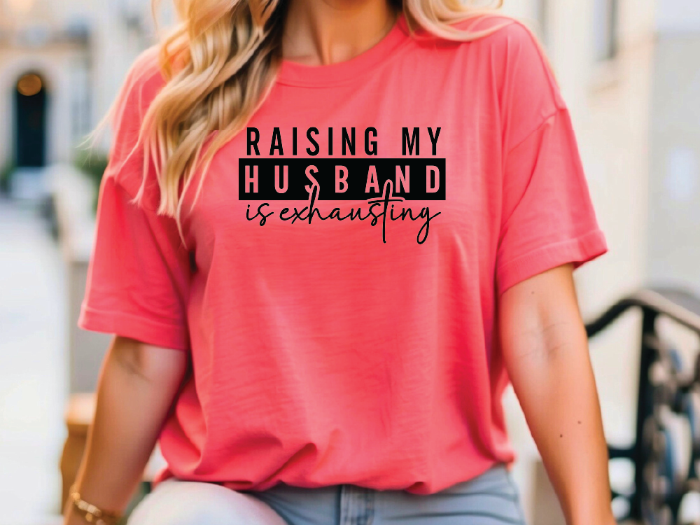 a woman wearing a pink shirt that says raising my husband is extraordinary