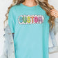 a woman wearing a turquoise shirt with the word custom printed on it