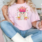 a woman sitting on a couch holding a pink t - shirt