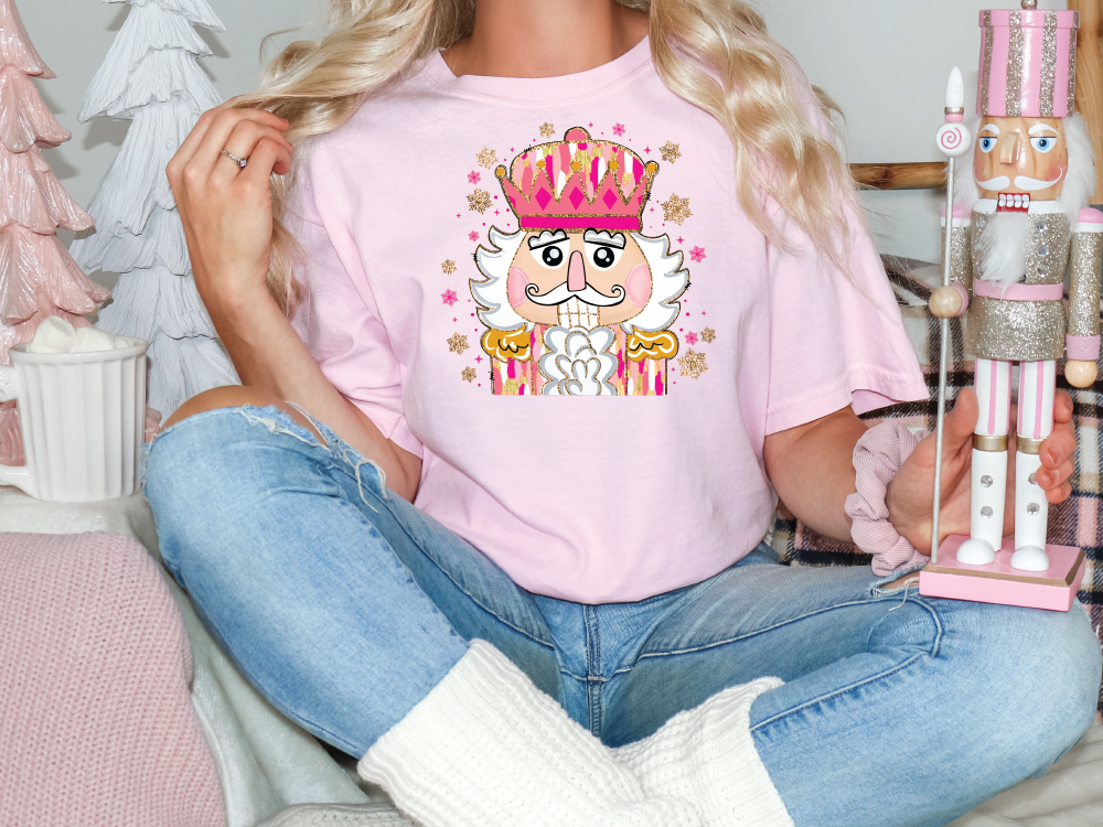 a woman sitting on a couch holding a pink t - shirt