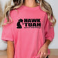 a woman wearing a pink t - shirt with the words hawk tuah on it