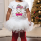 a little girl standing in front of a christmas tree