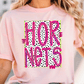 A woman wearing a pink t-shirt with the text "HOR NETS" printed on it.