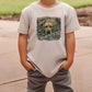 a young boy wearing a white shirt with a bear on it