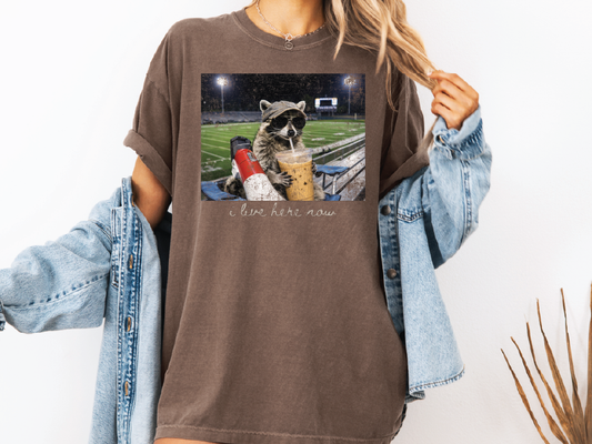 I Live Here Now Iced Coffee Racoon Football Mama Graphic T-Shirt