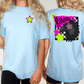 two women wearing light blue t-shirts with colorful designs on the back.