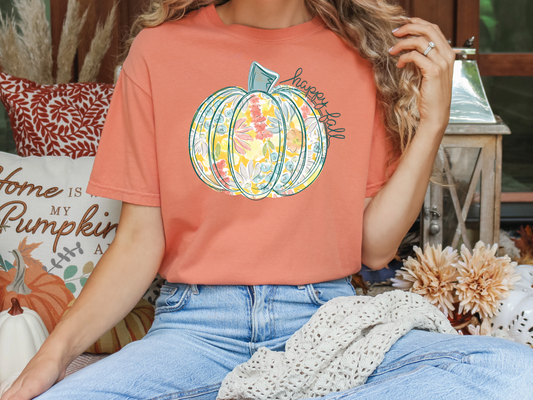 a woman sitting on a couch wearing a pumpkin t - shirt