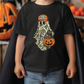 A child wearing a black t-shirt with a Halloween-themed graphic of a ghost holding a pumpkin and candy.