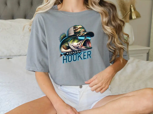 a woman sitting on a bed with a fish t - shirt on