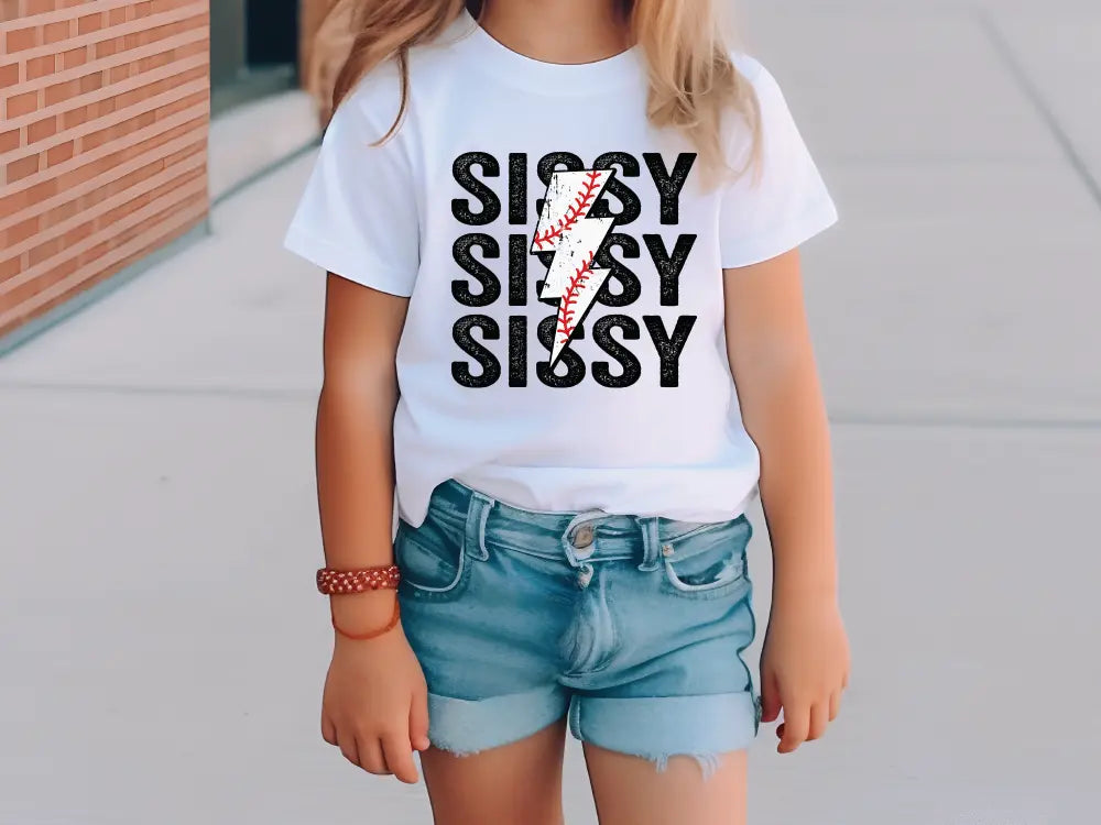 a little girl standing on a sidewalk wearing a baseball shirt