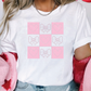 a woman wearing a white shirt with pink hearts on it