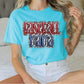 a woman sitting on a bed with a baseball shirt on