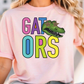 A person wearing a pink t-shirt with the text "GATORS" and a cartoon alligator graphic.
