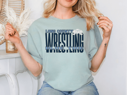 A woman wearing a light blue t-shirt with the text "LONG COUNTY WRESTLING BLUE TIME" printed on it.